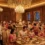 Elegant wedding banquet hall in Delhi, India, decorated with flowers and ambient lighting, with Indian couples, guests, and professional staff enjoying the event.